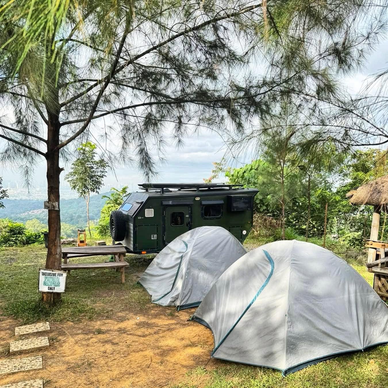 Forest campsite with a tent and comfortable outdoor setup
