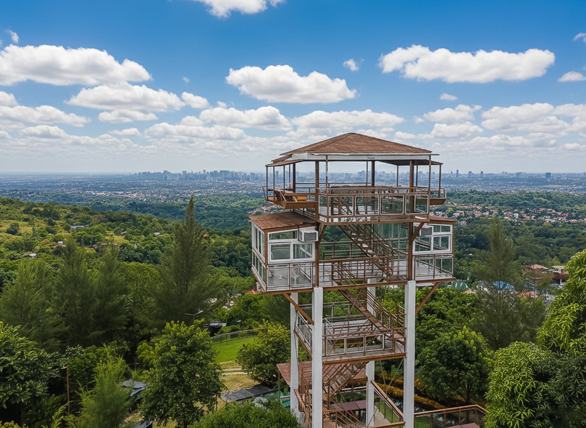 Sky Tower and nearby park grounds surrounded by forested hills