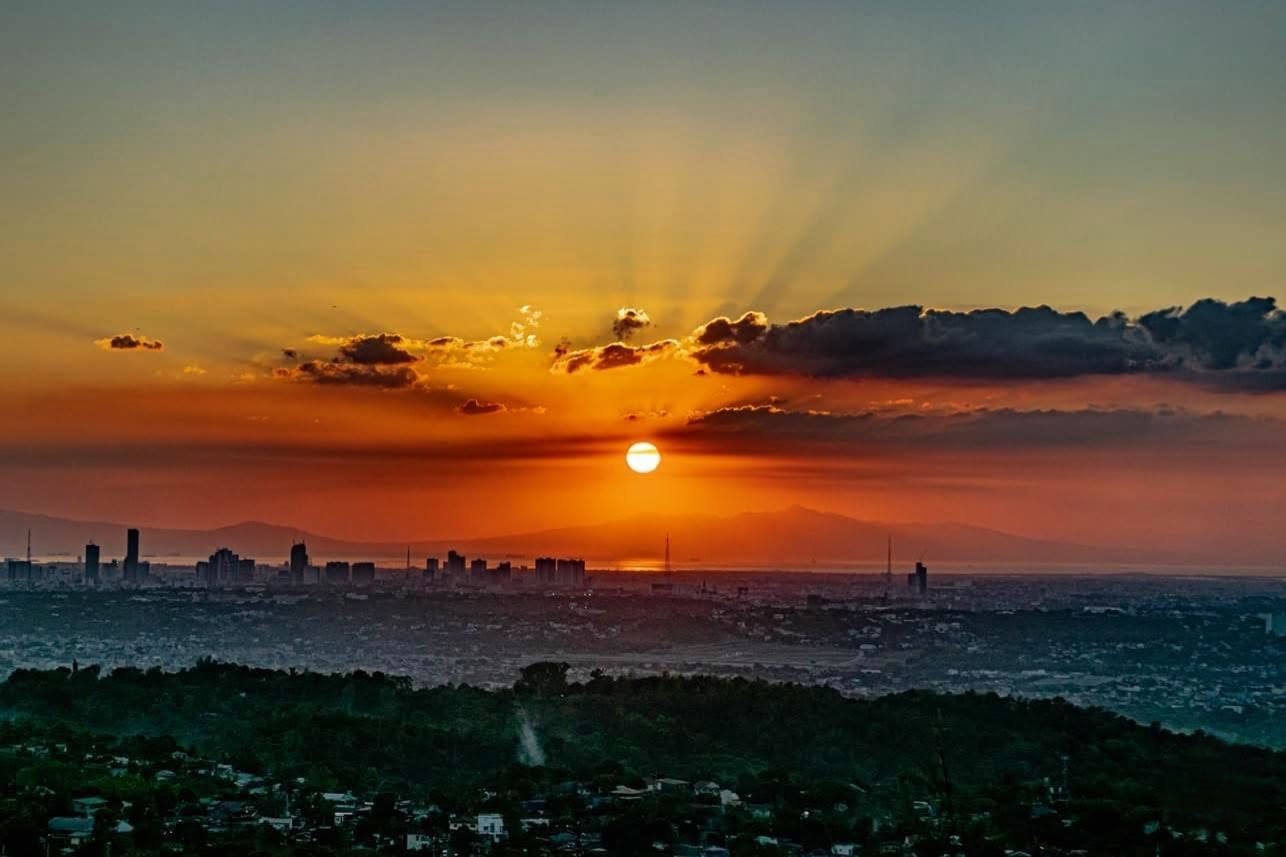 Orange sunset descending over the distant city skyline